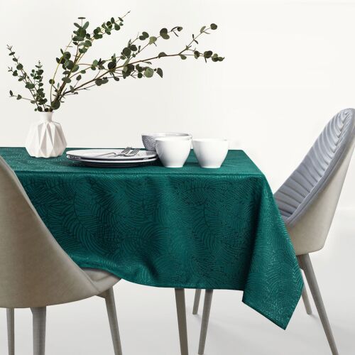 AmeliaHome Gaia tablecloth in bottle green with embossed leaf pattern, set on a table with chairs