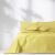 AmeliaHome Meadore yellow bedspread with pom poms on a bed