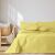 AmeliaHome Meadore yellow bedspread with pom poms on a bed in a bedroom setting