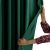 Woman touching AmeliaHome Velvet bottle green blackout curtain