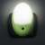 Green LED night light with motion sensor, plug-in, for indoor use, installed in a wall socket