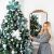Woman decorating Royal Trees Diamond Fir Christmas Tree with ornaments