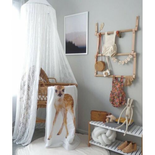 Fehér csipkés baldachin babaágyhoz, szarvas mintás takaróval, egy kiságyas szobában