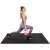 Woman exercising with kettlebell on Springos black puzzle exercise mat