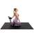 Woman stretching on Springos black puzzle exercise mat