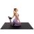 Woman stretching on black Springos puzzle exercise mat for fitness