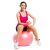 Woman exercising with dumbbell on pink fitness ball