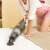 Deerma DX115C handheld vacuum cleaner cleaning a bed