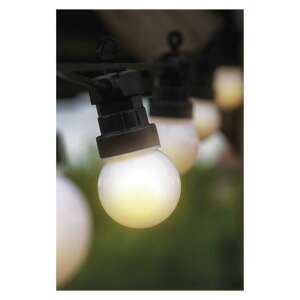 Close-up of a single warm white LED bulb on a black string light - Seasonal decoration