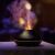 Ruhhy aroma diffuser humidifier with orange flame effect in a dark room