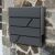 Pepita anthracite mailbox mounted on stone wall, modern design
