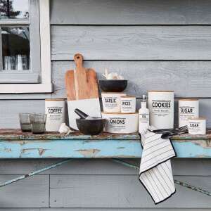 KARLTON BROS. konyhai tárolóedények, beleértve a kávét, cukrot, süteményeket, fokhagymát, fűszereket, hagymát, olajat és ecetet, egy rusztikus fa munkalapon - Bros