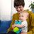 Baby Einstein Neptune's Sensory Sidekick Turtle plush toy being held by baby and parent