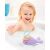 Happy child playing with Skip Hop Narwhal bath toy in bathtub