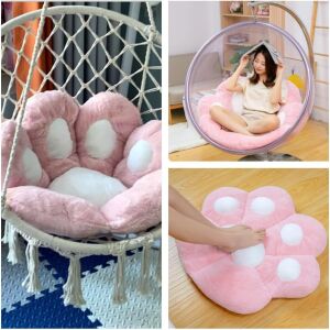 Kivágás, amely bemutatja a rózsaszín mancs alakú párnát különböző felhasználásokban: függő székben, a padlón és egy széken - Székpárna