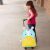 Child pulling a blue and yellow SKIP HOP unicorn rolling suitcase