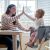 Mother and toddler high-fiving at table with Ingenuity high chair