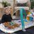 Kisgyermek ül a Baby Einstein Kick & Snooze játszószőnyegen zongorával