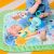 Baby sitting on Bright Starts Wild Wiggles play mat with elephant toy