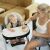 Mother feeding baby in Petite&Mars Tasty High Chair in Mature Olive color