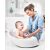 Mother bathing baby in white Skip Hop Moby bathtub