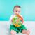 Baby playing with OBall Rollin Rainstick rattle while sitting