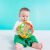 Baby playing with OBall Rollin Rainstick rattle while sitting