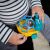 Baby holding OBALL Einstein Neptune Turtle Car Toy