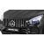 Egy fekete Mercedes Benz GT gyerek elektromos autó első hűtőrácsának részlete AMG jelvénnyel.