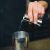 Bartender pouring liquid from jigger into shaker