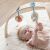 Baby reaching for plush toy on Nattou play mat with wooden arch