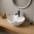 Owalna ceramiczna umywalka z czarną baterią na blacie