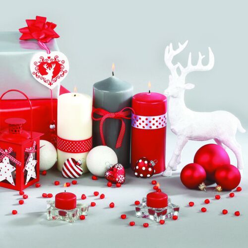 Karácsonyi dekoráció gyertyákkal, díszekkel és egy rénszarvas figurával.