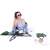 Woman sitting in a green Springos folding lounge chair with a phone and headphones