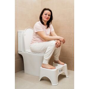 FizioTab® Classic WC-lábtartó, fehér, fürdőszobában használatban, nő ül a WC-n a lábtartóval - Fellépő