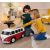 Gyerekek játszanak a BIG Baby VW T1 piros lábbal hajtós autóval beltérben, tároló