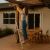 Woman using folding steel ladder to hang outdoor lights