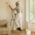 Man painting a wall using foldable steel step ladder