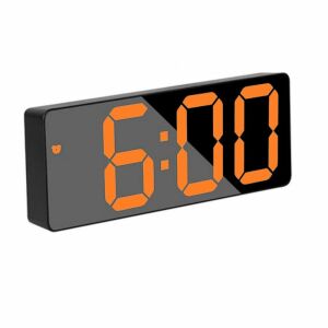 Schwarzer digitaler Wecker mit orangefarbener LED-Anzeige, die 6:00 Uhr anzeigt - Innenarchitektur