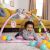 Baby playing on Bright Starts Rainbow Tropics 5-in-1 Activity Gym