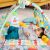 Baby lying on Bright Starts Totally Tropical 5-in-1 play mat with overhead gym