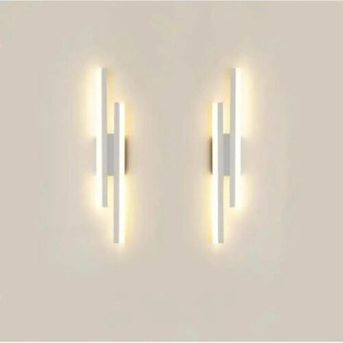 Pereche de lămpi de perete Soho LED acrilice albe care iluminează un perete.