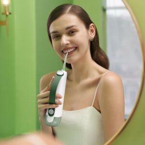 Frau benutzt Oclean W10 Munddusche im Badezimmer - Oclean