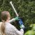 Woman trimming hedge with Scheppach C-HT570-X cordless hedge trimmer