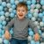 Boy playing in Kg0042 light blue, pearl, and gray ball pit