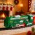Karácsonyi kisvasút zöld mozdony a pályán karácsonyi környezetben