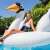 Woman relaxing on Intex Mega Swan Island inflatable pool float in a swimming pool