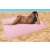 Woman relaxing on the pink sand-free beach mat at the beach