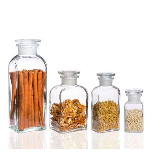 Set of 4 glass jars with airtight lids, perfect for storing spices, herbs, or other dry goods.