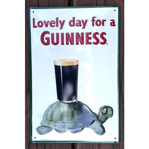 Guinness fém tábla teknőssel, amely egy pohár Guinness-t hordoz